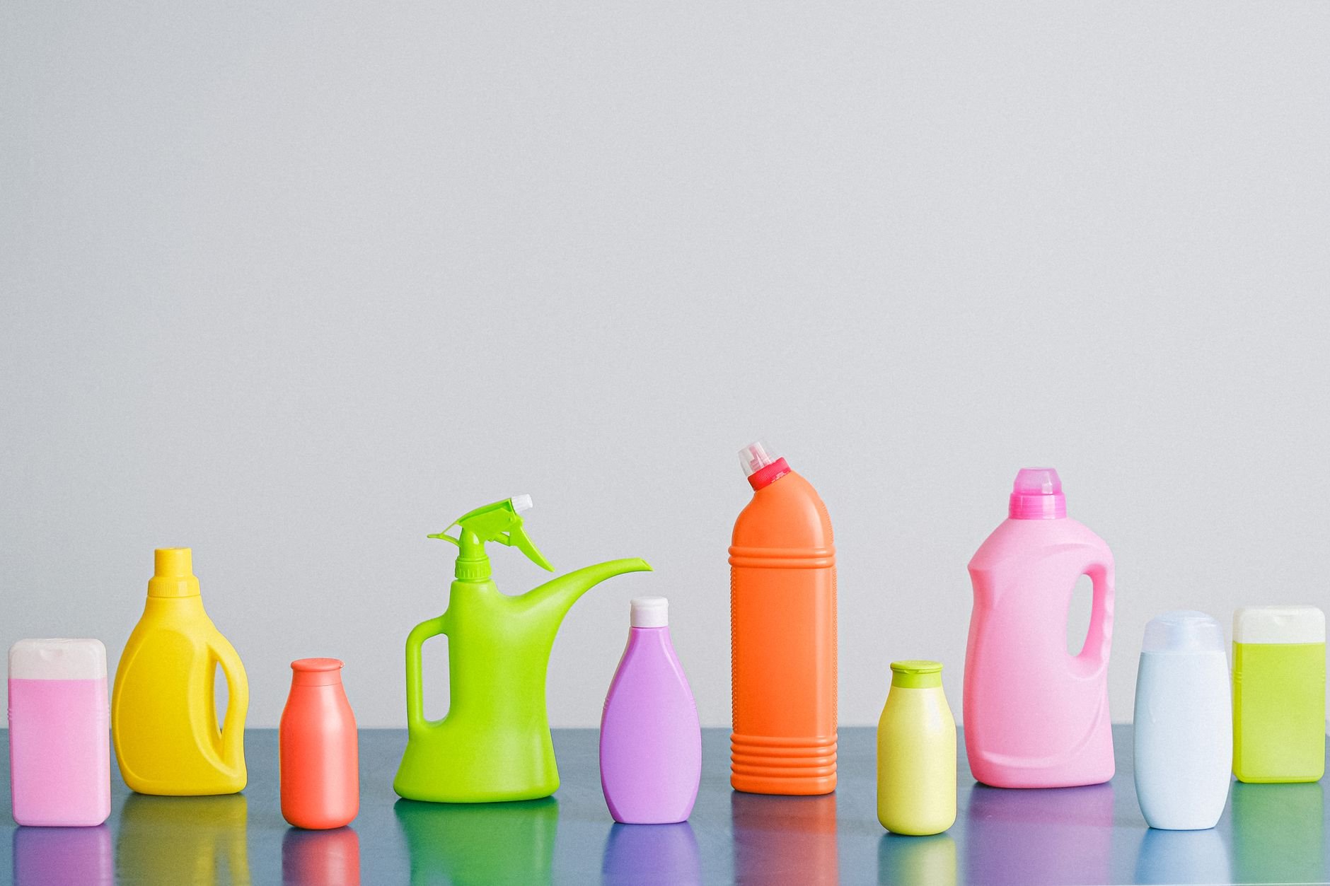Colorful household cleaning and care products arranged on a bright surface